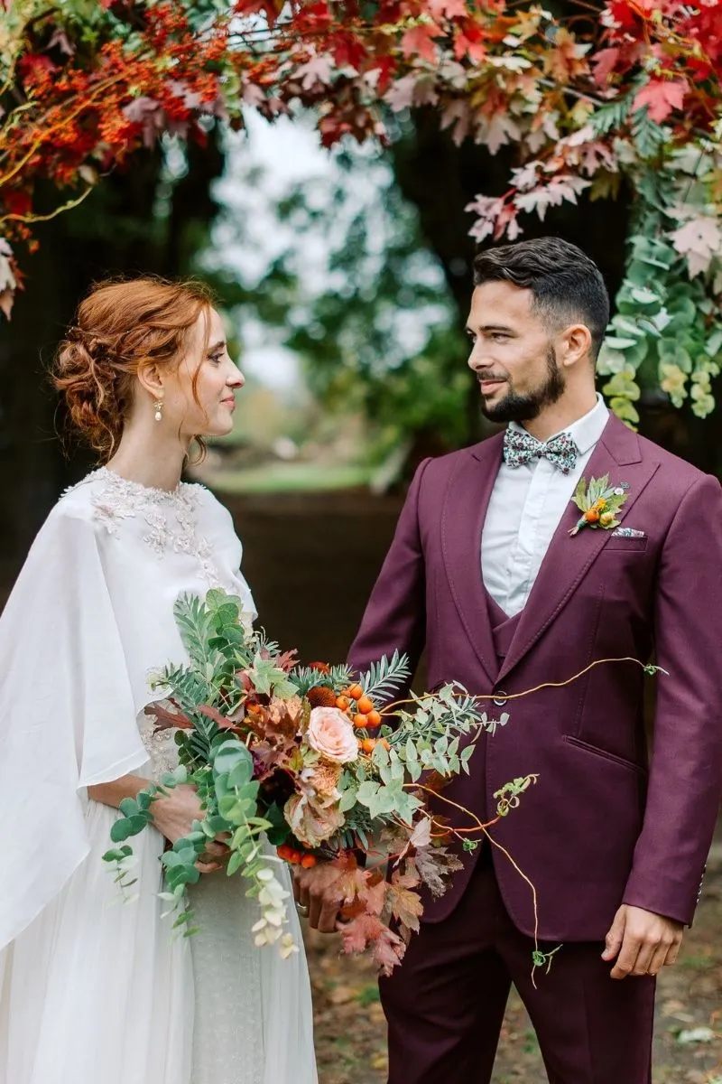 les mariés en dessous leur arche en feuilles et fleurs du Domaine de Quincampois