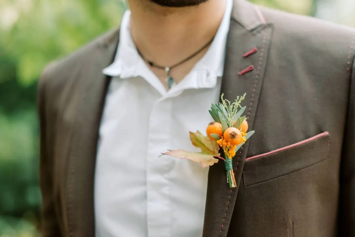 zoom sur la tenue du témoin avec sa broche du Domaine de Quincampois